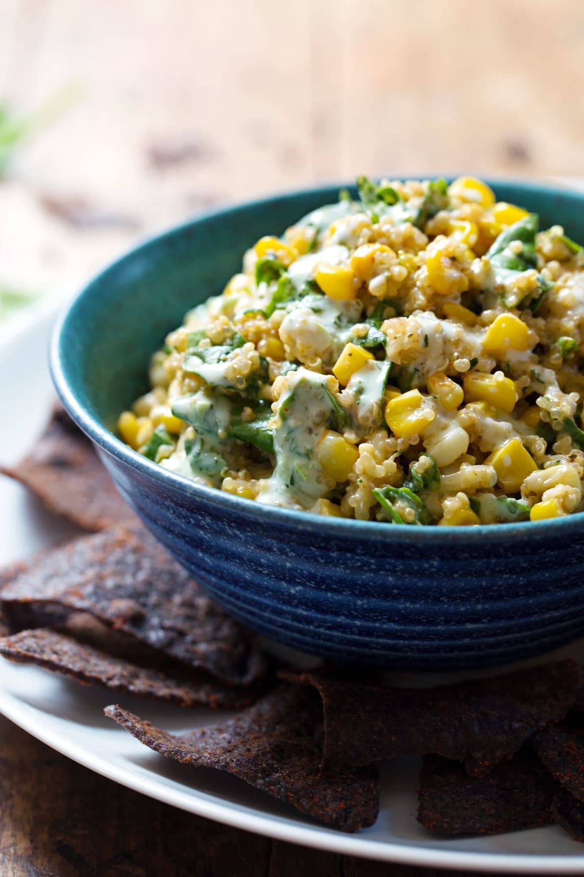 Jalapeño Quinoa Corn Dip in a blue bowl with chips.